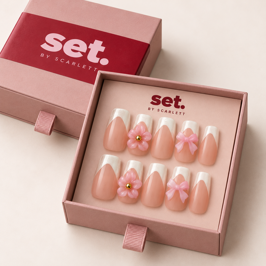 Bow Peep: White French tips, raised pink flowers, pink bows and gold-tone bead centres. Digitally styled packaging mockup based on Scarlett's photographed nail set.