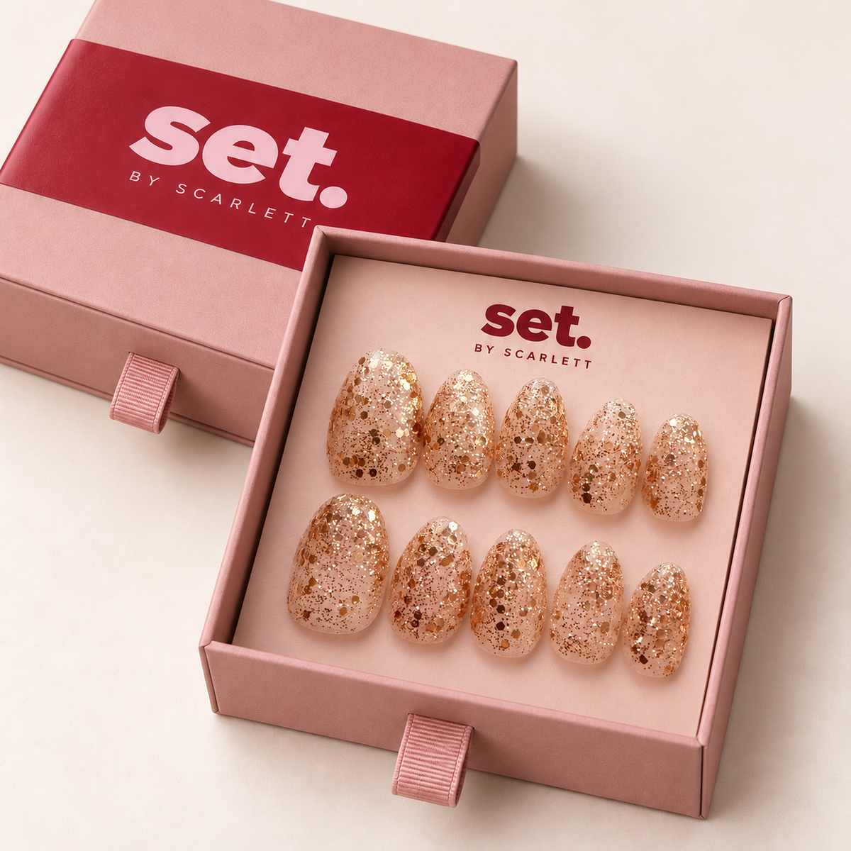 Champagne Pop: Champagne-gold glitter over a sheer blush base. Digitally styled packaging mockup based on Scarlett's photographed nail set.